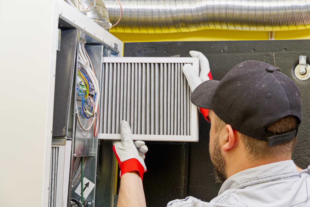 technician installing a new filter for hvac